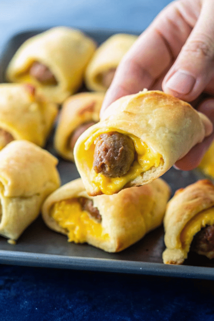 Freshly baked sausage egg breakfast roll ups with golden brown crescent dough.