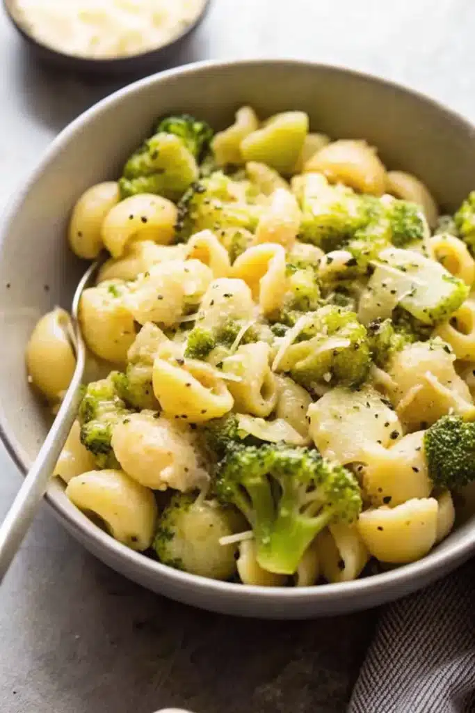 Close-up of a forkful of Broccoli Cheese Pasta with broccoli and melted cheese
