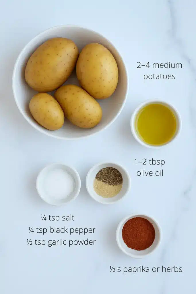 Ingredients for air fryer sliced potatoes: sliced potatoes, olive oil, salt, black pepper, garlic powder and optional paprika on a kitchen counter